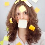 Woman with sticky notes all over, including over her mouth